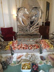 Swan ice sculpture surrounded by cold shellfish spread