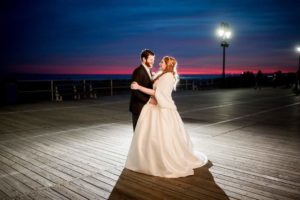 bride and groom on boardwalk at night