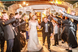 bride and groom under sparklers outside hotel